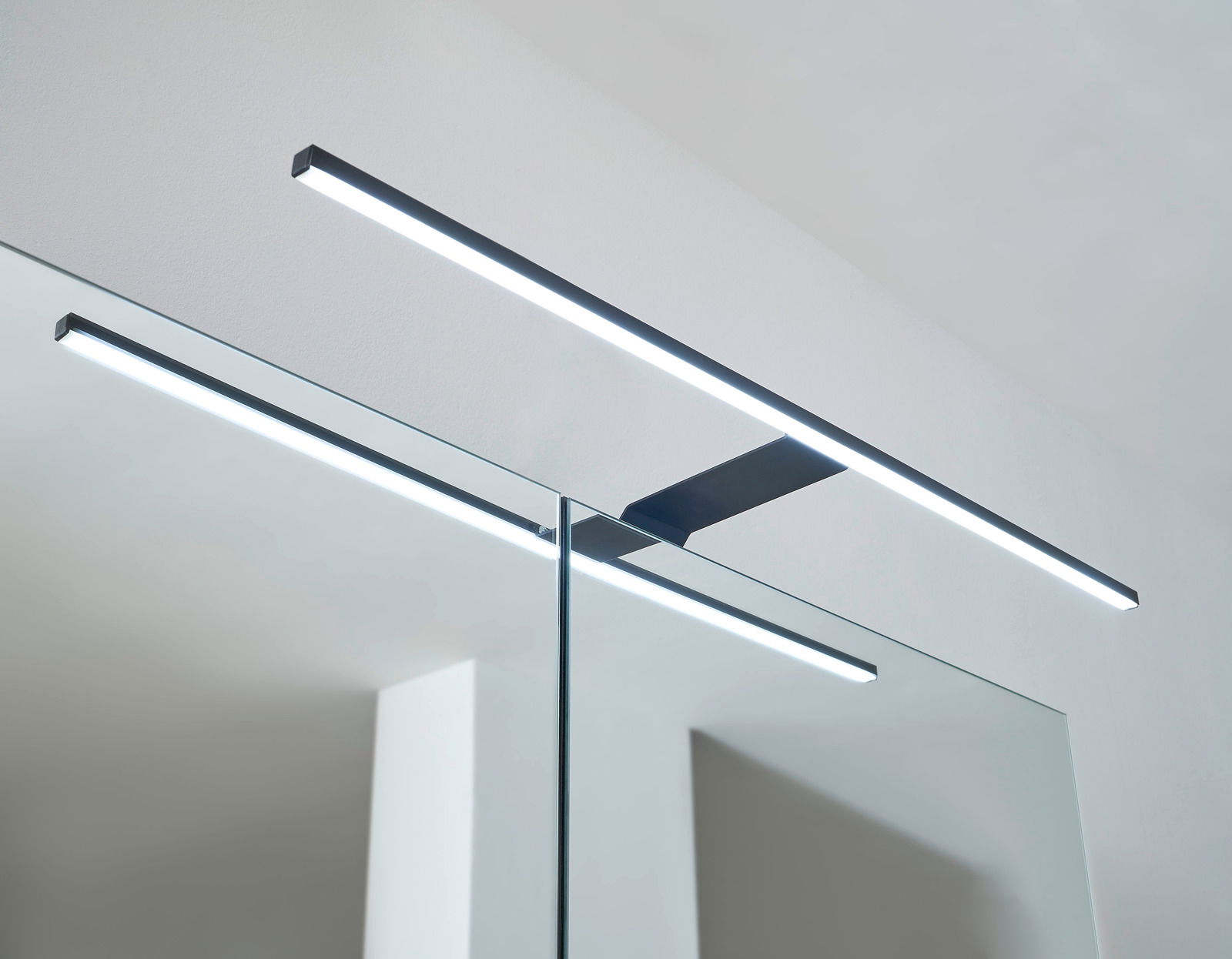 Moderne LED-Leuchte auf einem Spiegelschrank, seitliche Perspektive