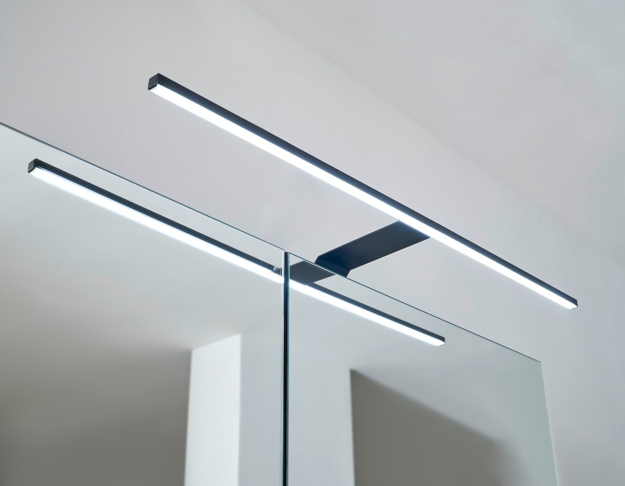 Moderne LED-Leuchte auf einem Spiegelschrank, seitliche Perspektive