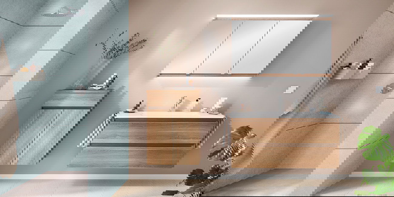 Helles Bad mit Holzschränken, großer Dusche, Spiegel und grüner Pflanze.