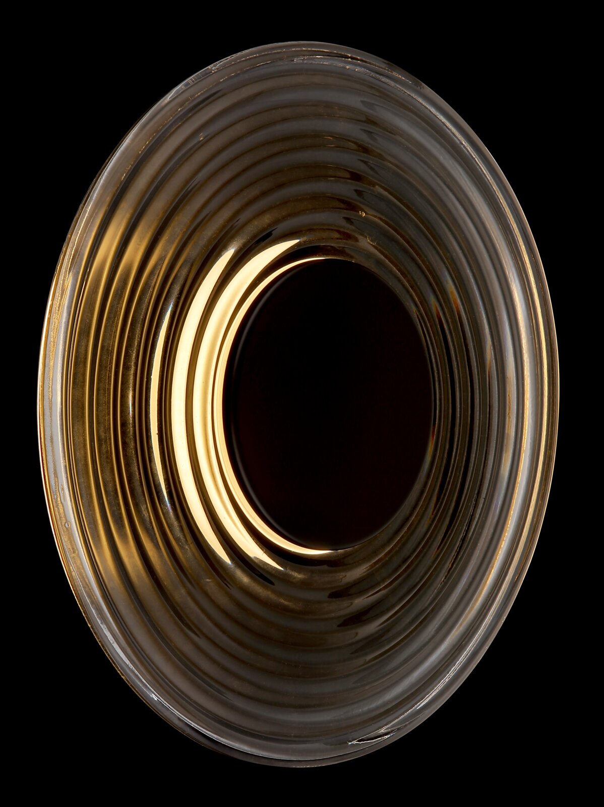 Runde Deckenleuchte aus geriffeltem, rauchfarbenem Glas mit warmem Licht, Draufsicht von unten auf schwarzem Hintergrund