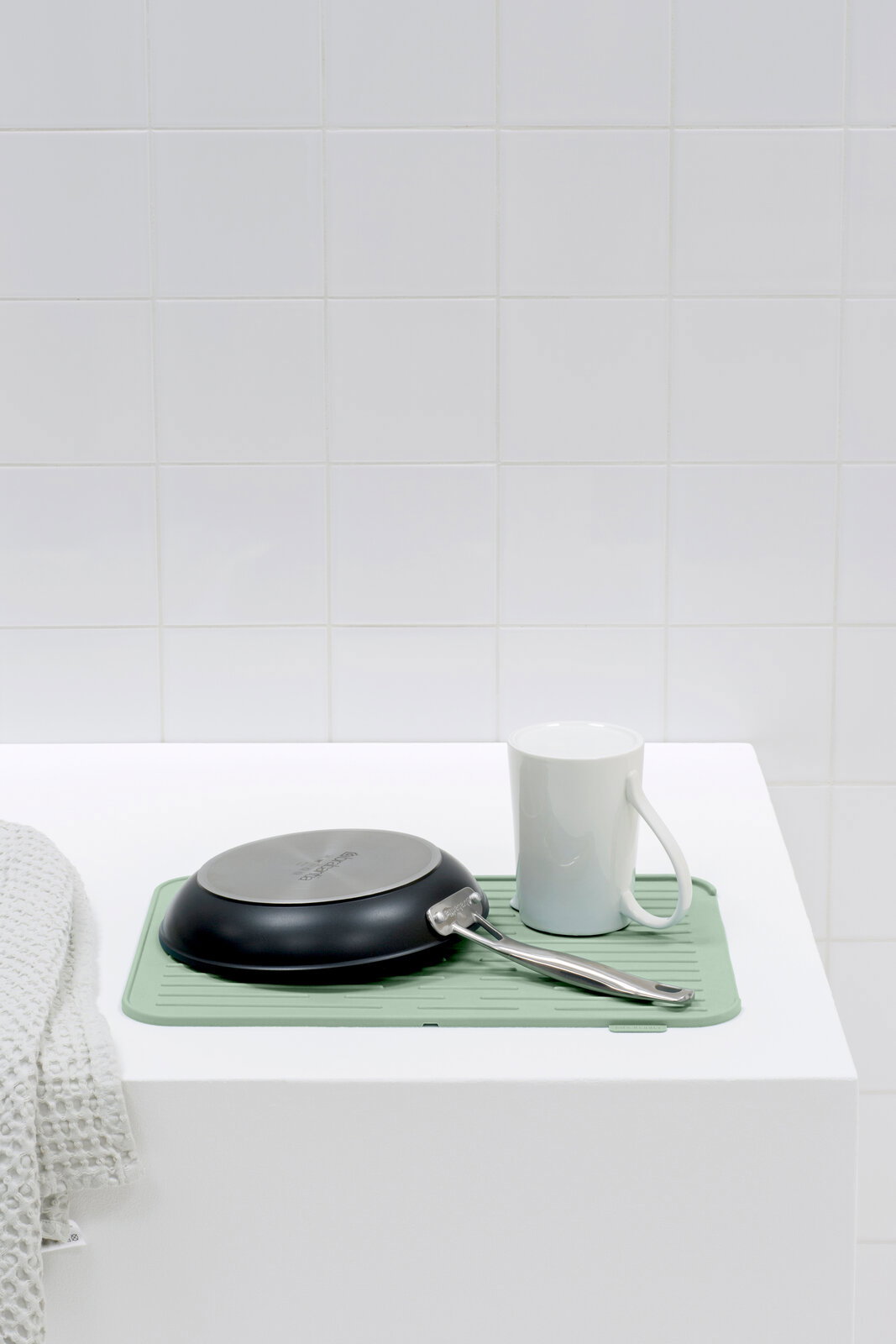 Silikon Abtropfmatte in mintgrün mit einer Pfanne und einer Tasse darauf, seitliche Perspektive