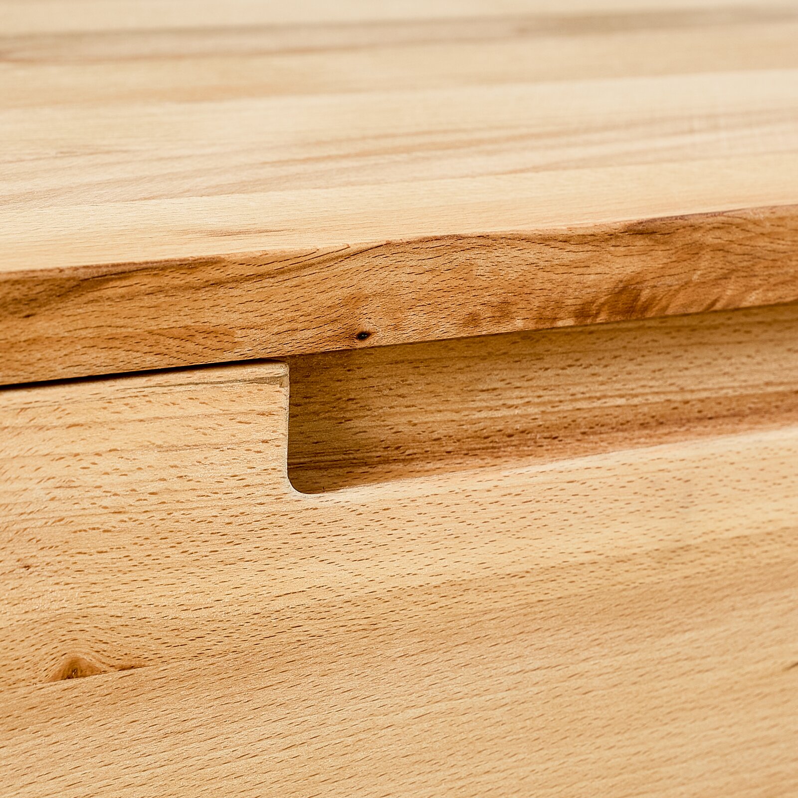 Nahaufnahme eines Hängeschuhschranks aus Holz mit natürlicher Maserung und Griffmulde.
