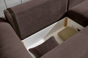 Nahaufnahme einer braunen Rundecke mit Stauraum, geöffnet, mit Kissen und Decke. Perspektive von oben.