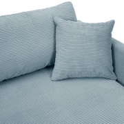 Nahaufnahme einer Rundecke mit geripptem Stoff in hellblau, inklusive passendem Kissen.