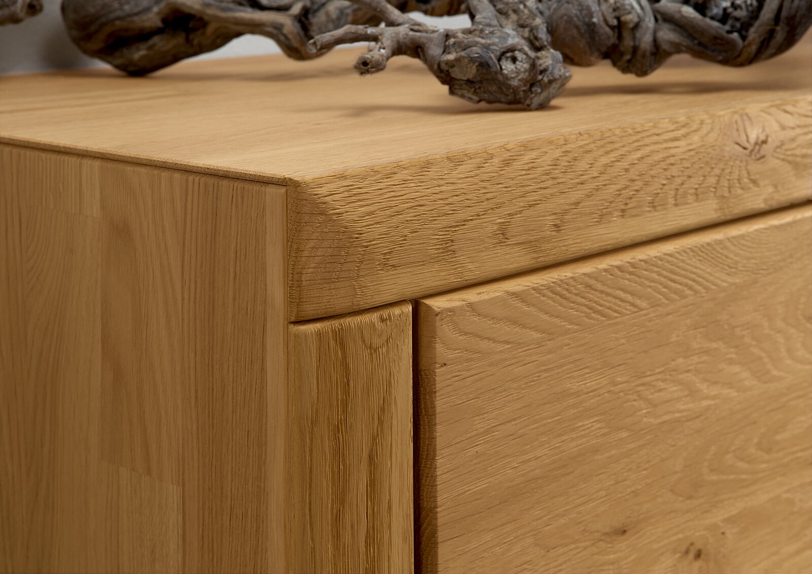 Close-up van een houten wandcombinatie met natuurlijke nerf en een decoratieve knoest aan de bovenkant, gezien vanaf de zijkant.
