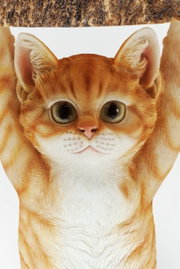 Nahaufnahme einer dekorativen Katzenfigur, die einen Tisch stützt, mit detailliertem Fellmuster und großen Augen, aus der Vorderansicht.
