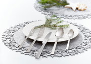 Elegantes, poliertes Besteckset King 60-tlg. auf einem festlich gedeckten Tisch mit Teller, Tannenzweig und weihnachtlicher Dekoration, aus der Vogelperspektive.