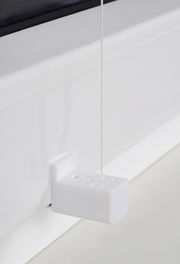 Nahaufnahme eines weißen Plissee-Mechanismus mit Schnur, seitliche Perspektive