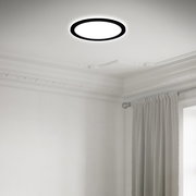 Moderne LED-Deckenleuchte in einem eleganten Raum, von unten betrachtet, mit einem schlichten, runden Design und schwarzem Rahmen.
