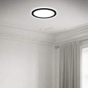 Moderne LED-Deckenleuchte in einem eleganten Raum, von unten betrachtet, mit einem schlichten, runden Design und schwarzem Rahmen.