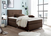 Gemütliches Boxspringbett in einem modernen Schlafzimmer, seitliche Perspektive