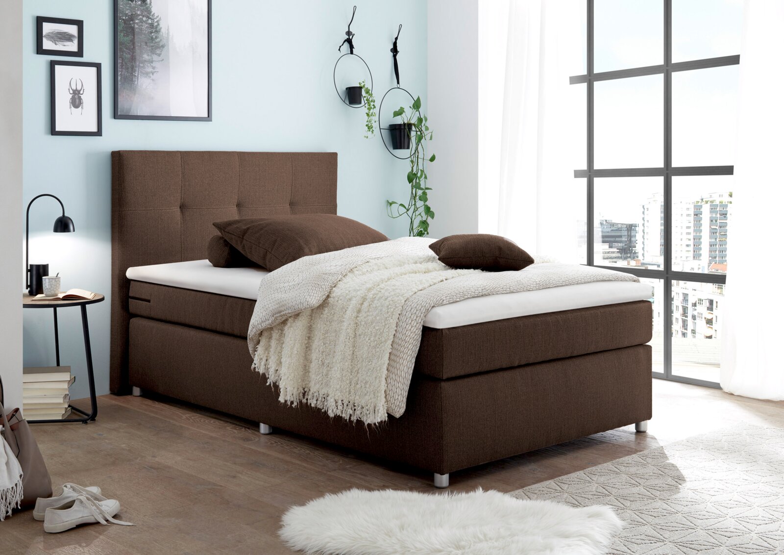 Gemütliches Boxspringbett in einem modernen Schlafzimmer, seitliche Perspektive