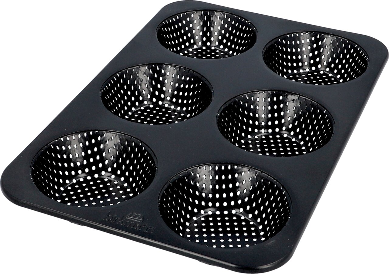 Zwarte muffinvorm met zes ronde, geperforeerde holtes, in perspectief van bovenaf gefotografeerd.