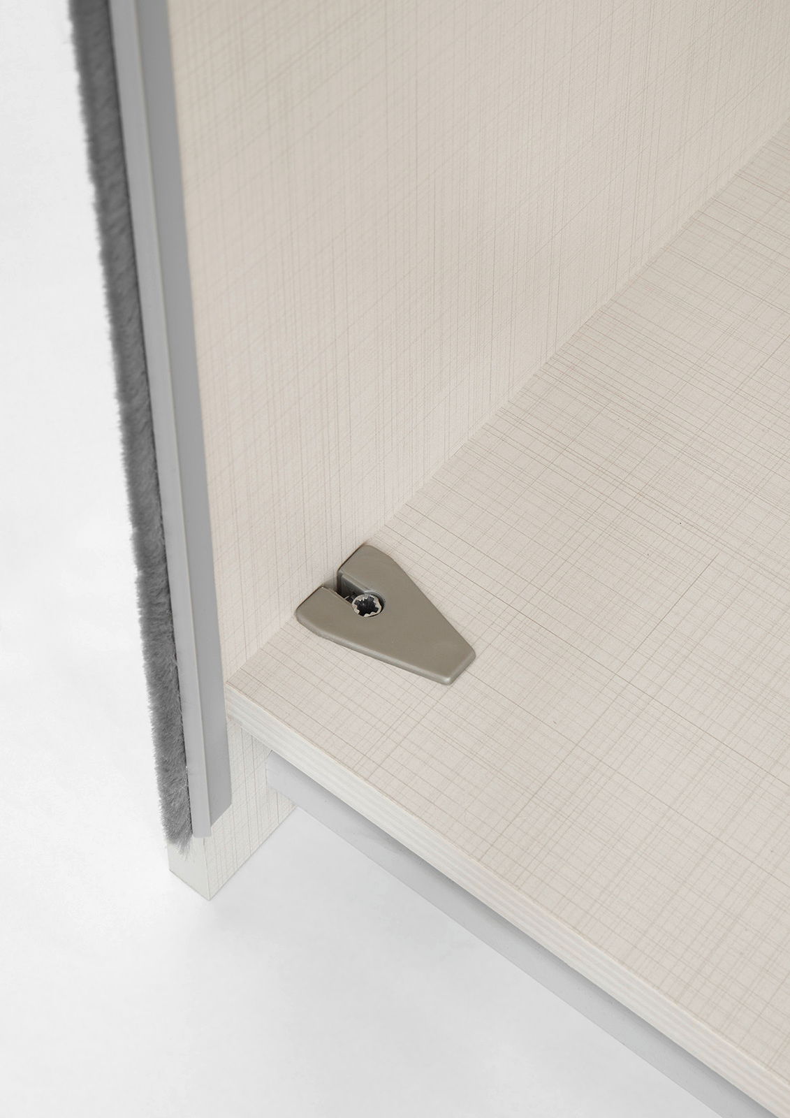 Nahaufnahme einer Ecke eines Schwebetürenschranks mit Metallbeschlag, von oben betrachtet.