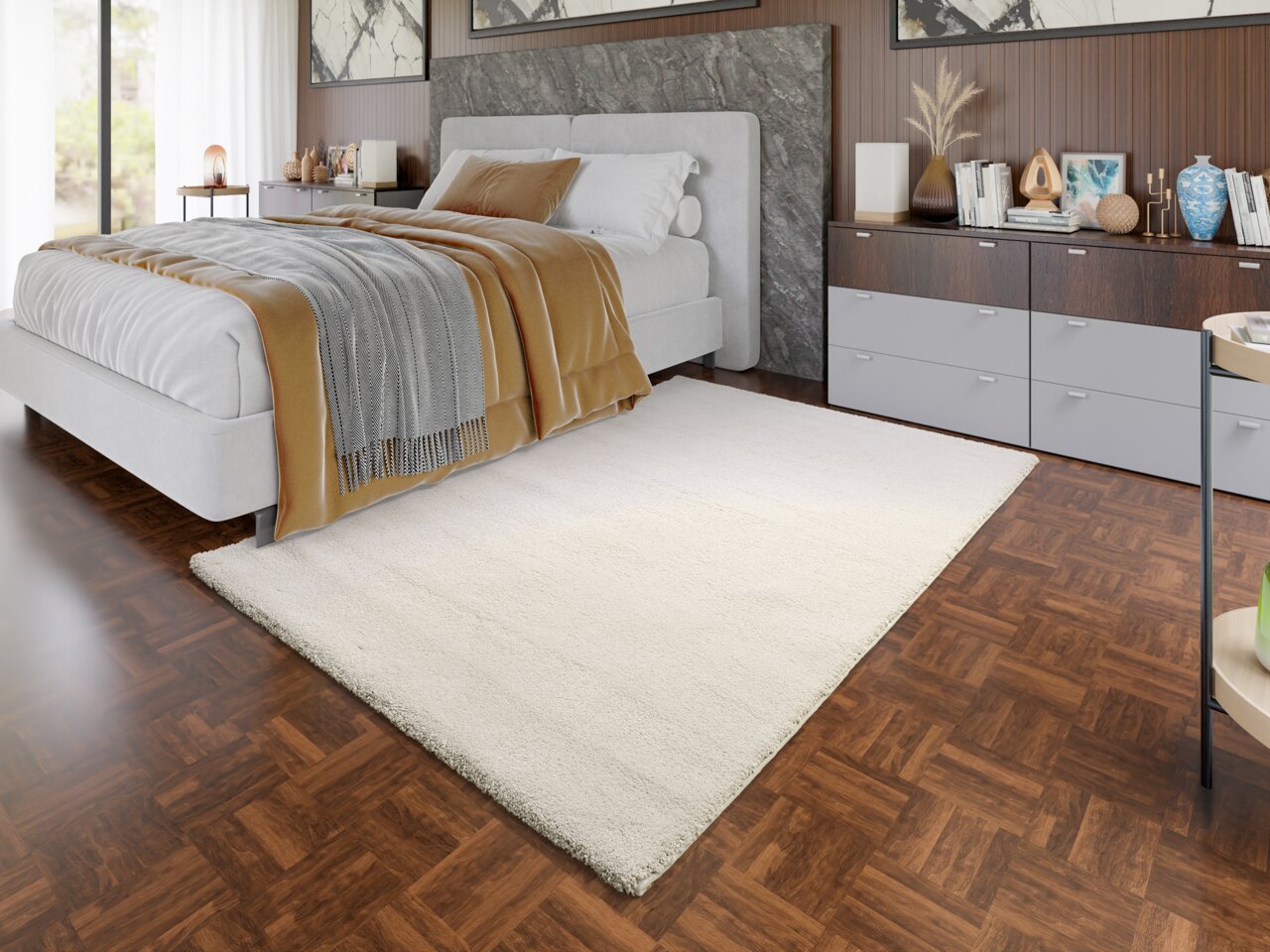 OCI Uni-Teppich NEW VILLA MELANGE Ein cremefarbener Uni-Teppich liegt in einem modernen Schlafzimmer mit Holzboden, neben einem grauen Bett. Die Perspektive zeigt den Teppich von schräg oben.