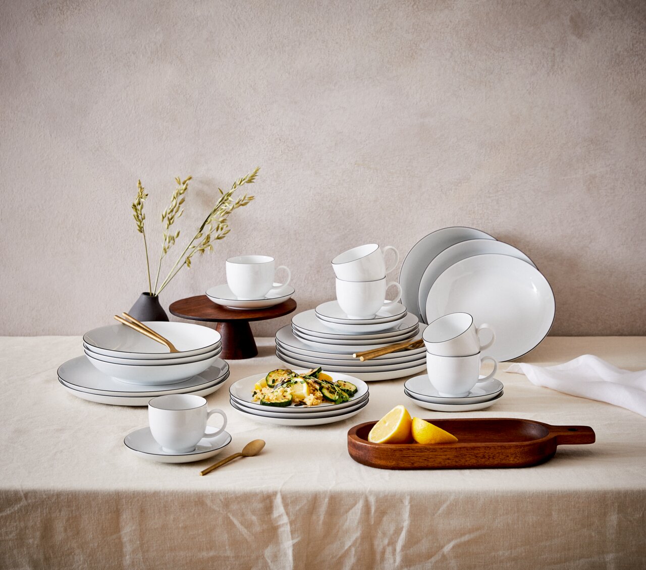 Servies Lido Black, 30-delig, elegant op een tafel gerangschikt, met kopjes, borden en schalen in zijaanzicht.