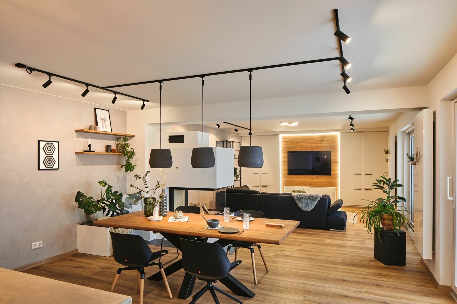 Moderne Wohnzimmerszene mit Schienenspot Tubo an der Decke, aus der Perspektive des Essbereichs fotografiert.