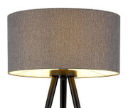 Graue Stehlampe mit zylindrischem Stoffschirm und schwarzem Dreibein-Gestell, warm leuchtend, Frontansicht leicht von unten vor weißem Hintergrund