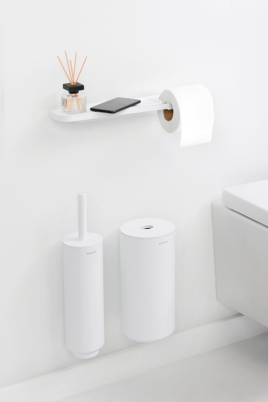Moderner Toilettenpapierhalter mit Ablage, seitliche Perspektive, mit Duftstäbchen und Smartphone auf der Ablage.