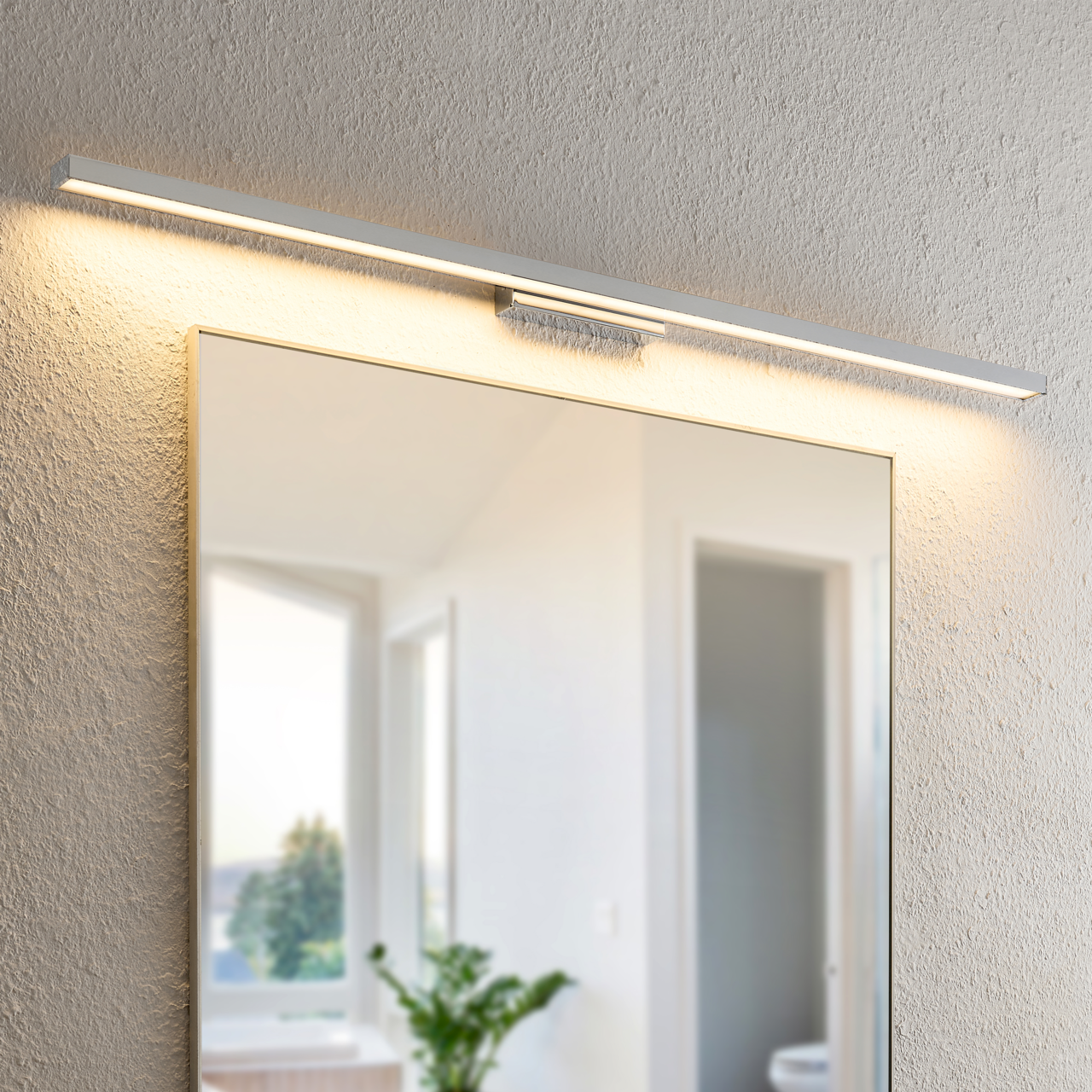 Moderne LED-Wandleuchte über einem Spiegel, seitliche Perspektive