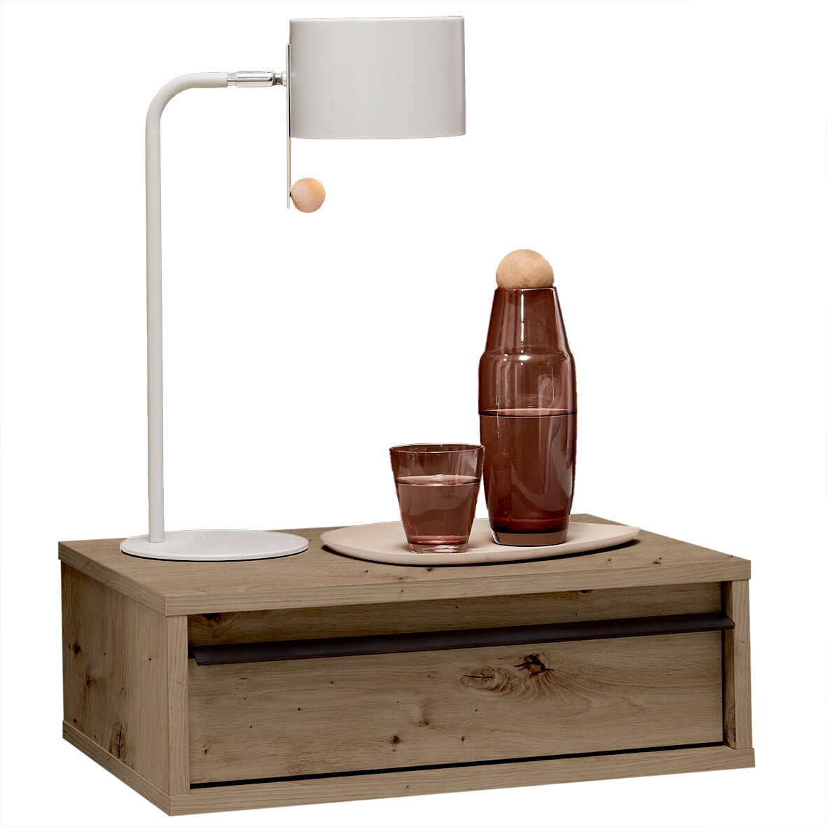 Holz-Nachttisch mit Schublade in Eichenoptik, darauf weiße Tischlampe und braune Glasflasche mit Glas auf Tablett, frontal aus leicht erhöhter Perspektive