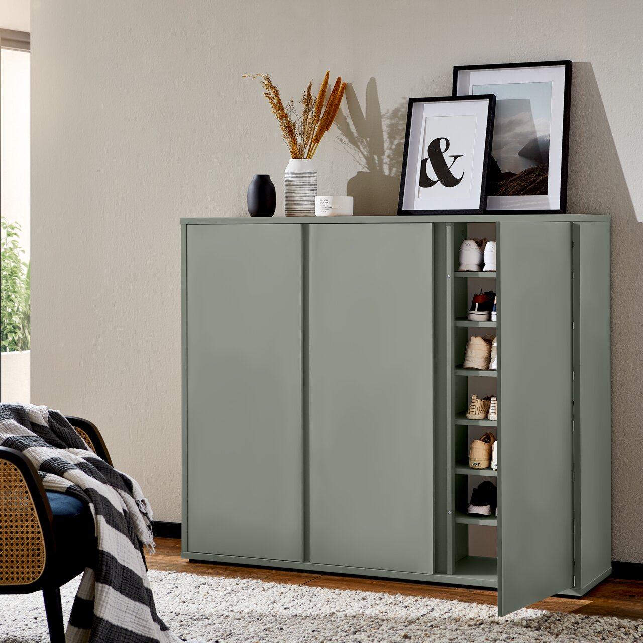 XORA Schuhschrank LIV Moderner Schuhschrank in einem Wohnzimmer, teilweise geöffnet, mit mehreren Paar Schuhen sichtbar. Perspektive von vorne.