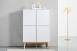 Frontale Ansicht eines modernen weißen Highboards mit vier Türen und Holzbeinen, dekoriert mit Vasen und Büchern auf der Oberseite, neben einer goldenen Stehlampe.