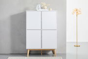 Frontale Ansicht eines modernen weißen Highboards mit vier Türen und Holzbeinen, dekoriert mit Vasen und Büchern auf der Oberseite, neben einer goldenen Stehlampe.