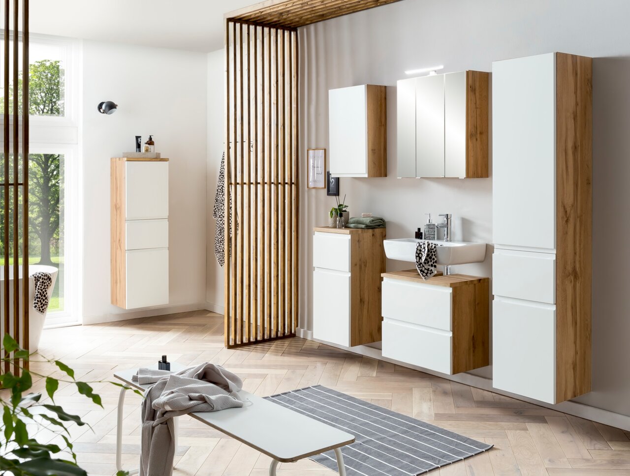 Moderne wastafelonderkast in houtlook met witte fronten, van voren gefotografeerd in een stijlvol ingerichte badkamer.