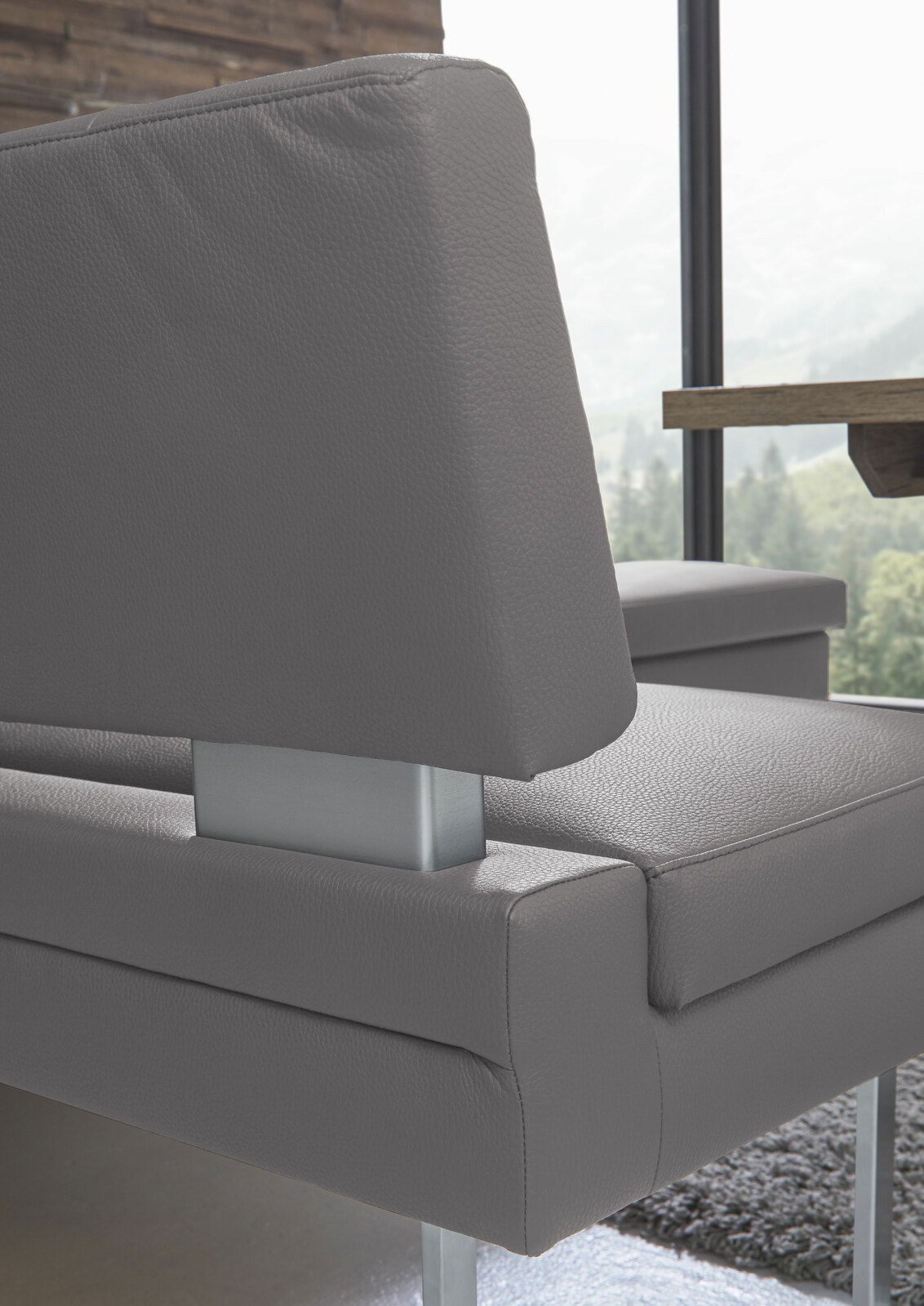 Nahaufnahme einer modernen grauen Eckbank mit Metallakzenten, seitliche Perspektive