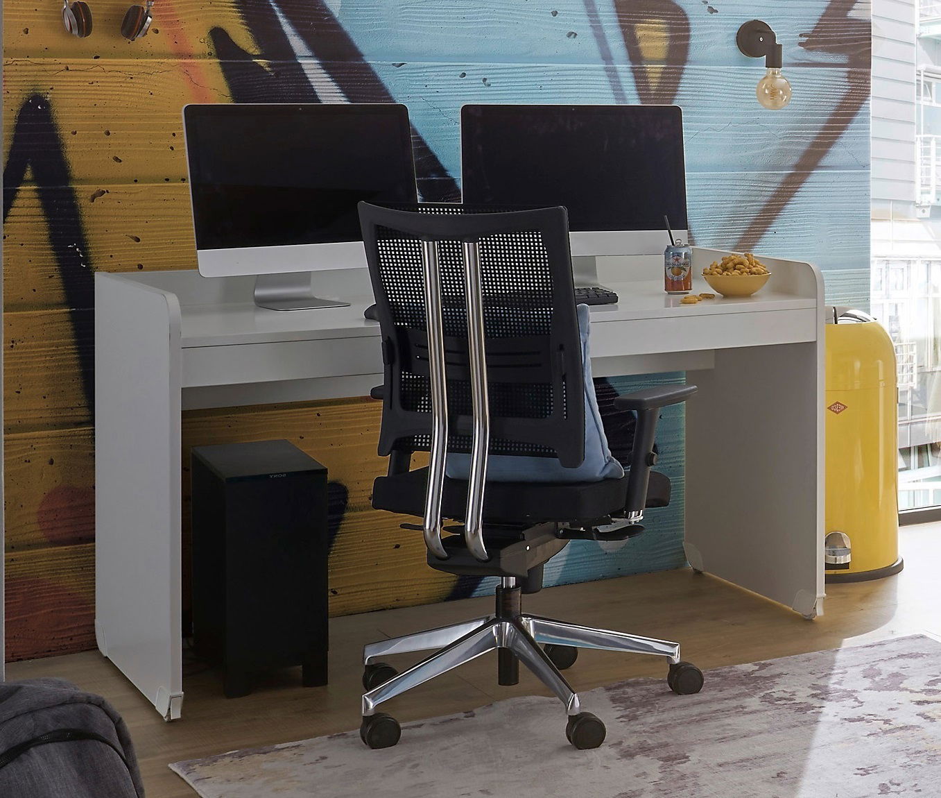 Moderner Schreibtisch mit zwei Monitoren, ergonomischem Bürostuhl und stilvollem Hintergrund, seitliche Perspektive