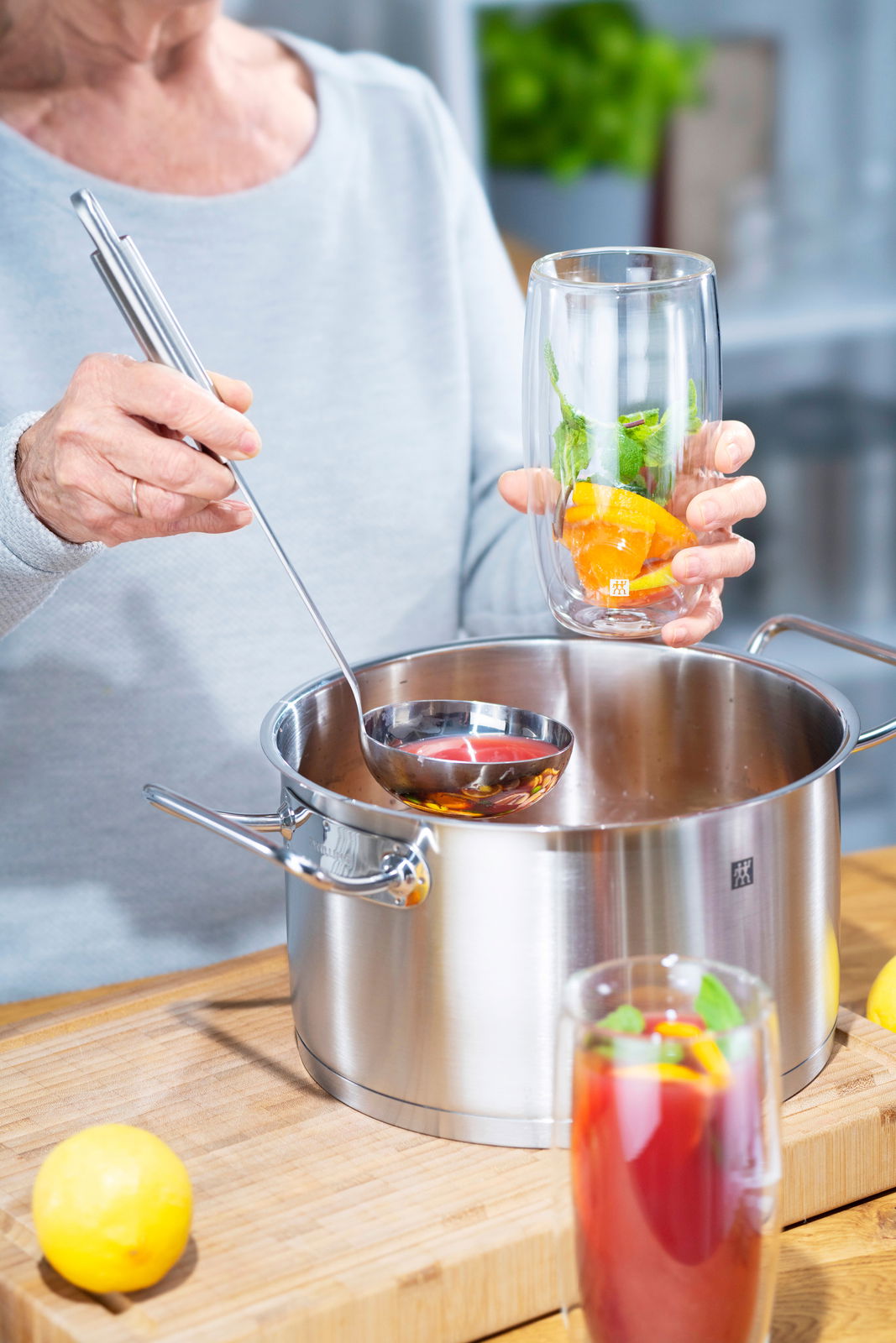 Person schöpft mit einem Schöpflöffel Pro aus einem Topf, seitliche Perspektive.