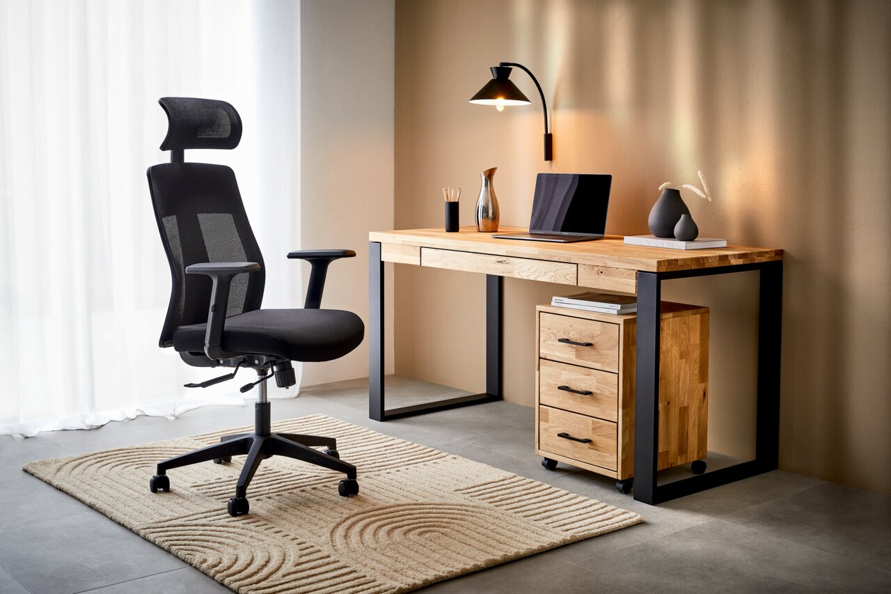 Moderner schwarzer Drehstuhl mit hoher Rückenlehne und Kopfstütze, seitliche Perspektive, neben einem Holztisch mit Metallbeinen in einem stilvollen Büro.