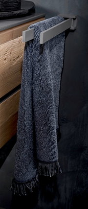 Moderner Handtuchhalter aus Metall mit einem dunkelblauen Handtuch, seitliche Perspektive.