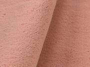 Nahaufnahme eines rosafarbenen Fellteppichs mit weicher Textur.