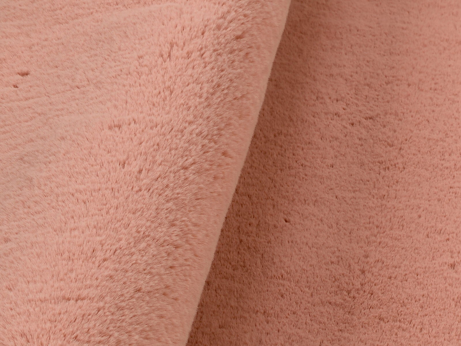 Nahaufnahme eines rosafarbenen Fellteppichs mit weicher Textur.