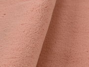 Nahaufnahme eines rosafarbenen Fellteppichs mit weicher Textur.