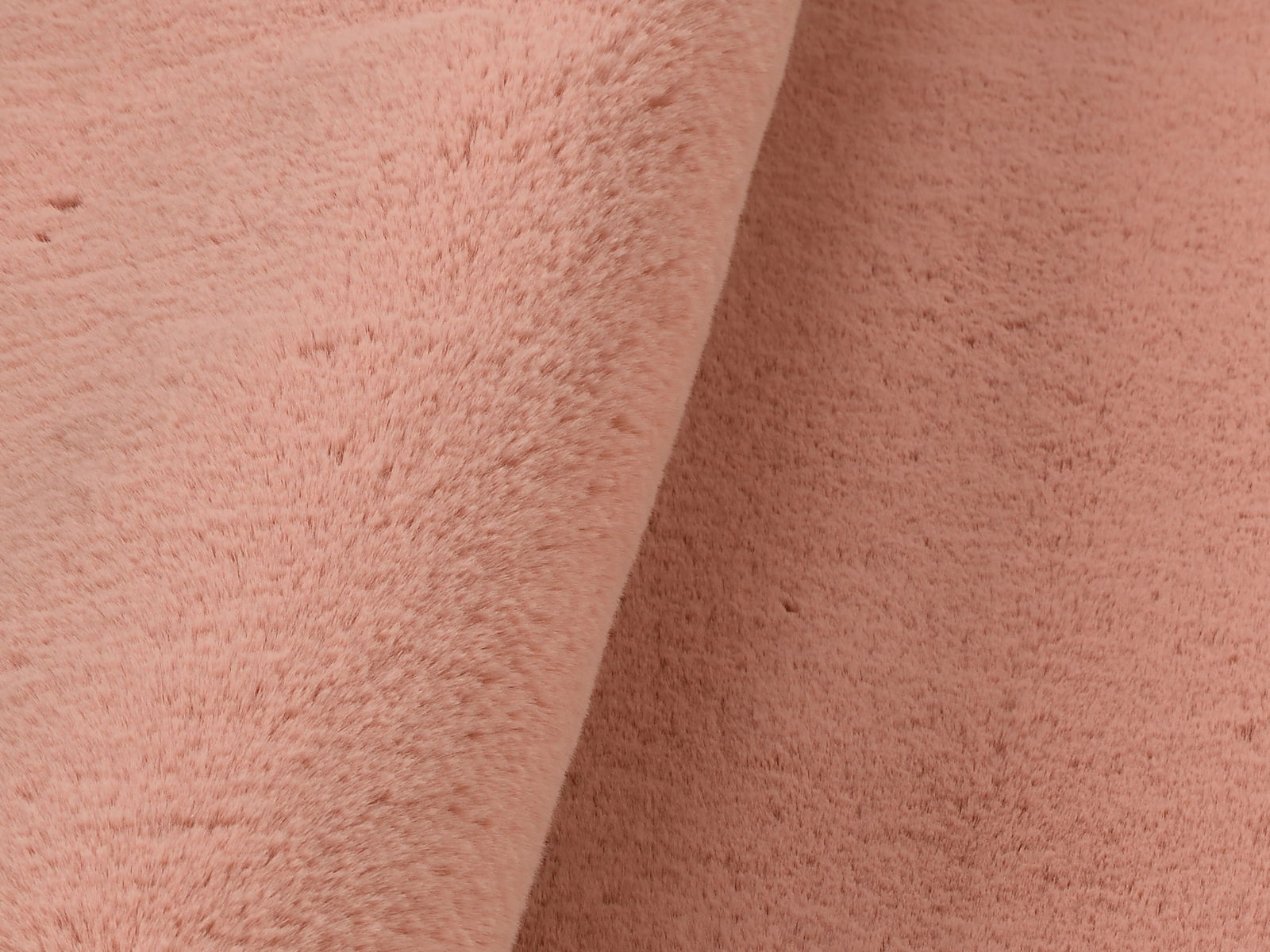 Nahaufnahme eines rosafarbenen Fellteppichs mit weicher Textur.