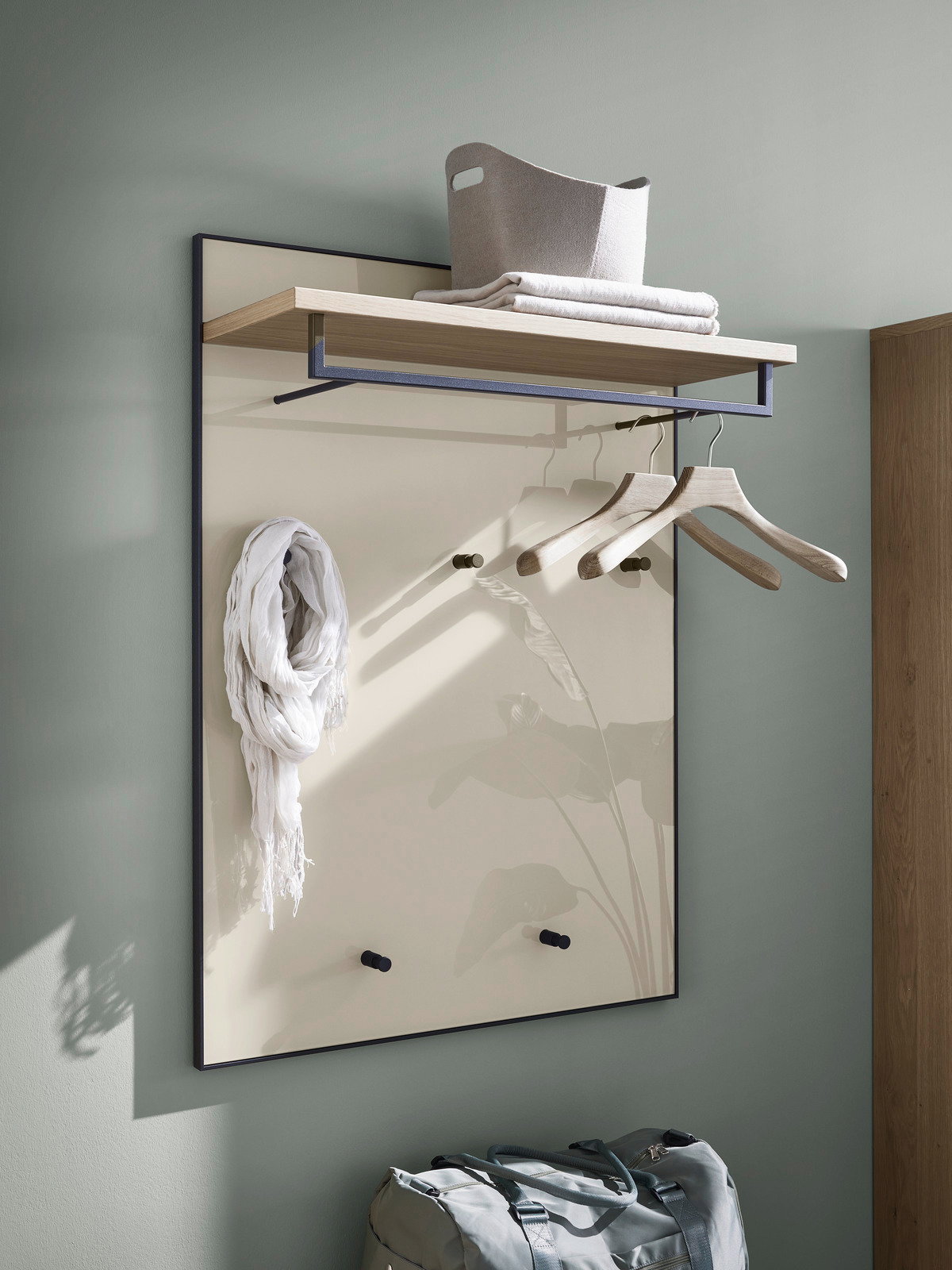 Garderobenpaneel mit Holzablage, Kleiderhaken und Kleiderbügeln, seitliche Perspektive