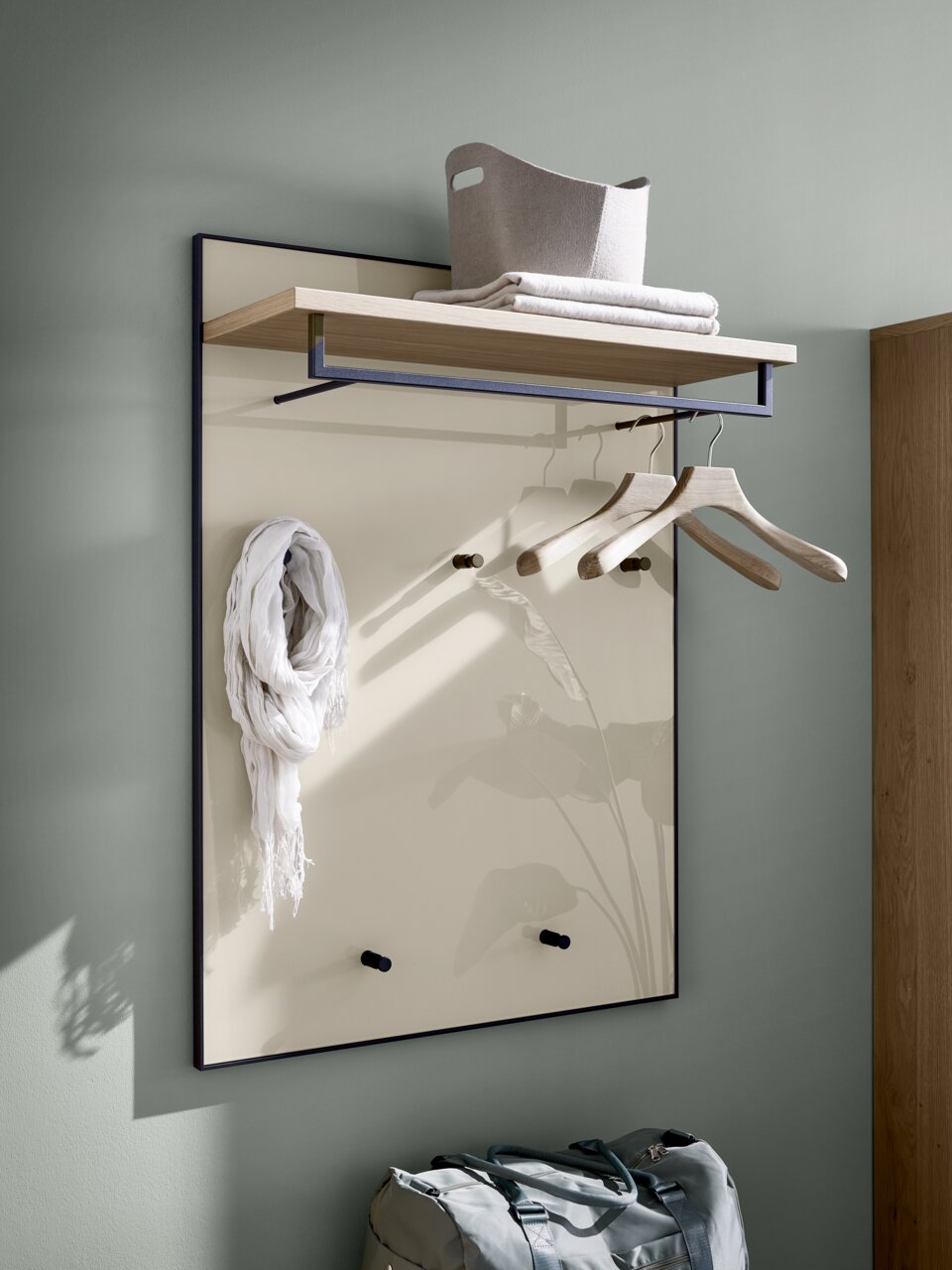 Garderobepaneel met houten plank, kledinghaken en kleerhangers, zijaanzicht
