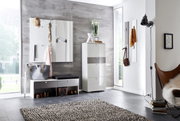 Moderne garderobe in een lichte ruimte met een grijze muur, bestaande uit een witte kast, een bankje met opbergruimte en wandhaken. Aanzicht van voren.