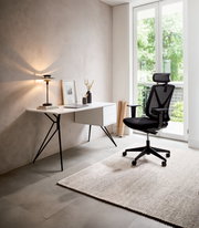 Moderner Drehstuhl in einem hellen, minimalistischen Büro mit Blick auf einen Schreibtisch und ein großes Fenster.