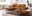 Ein stilvolles Wohnzimmer mit braunem Ledersofa, passendem Hocker, Teppich und moderner Dekoration.