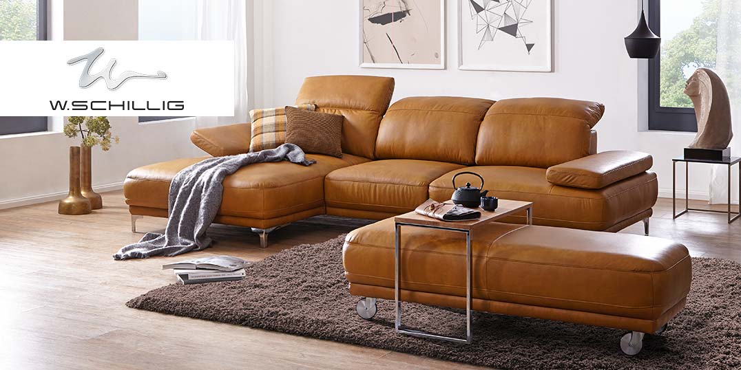 Een stijlvolle woonkamer met een bruine leren bank, een bijpassende poef, een tapijt en een moderne inrichting.