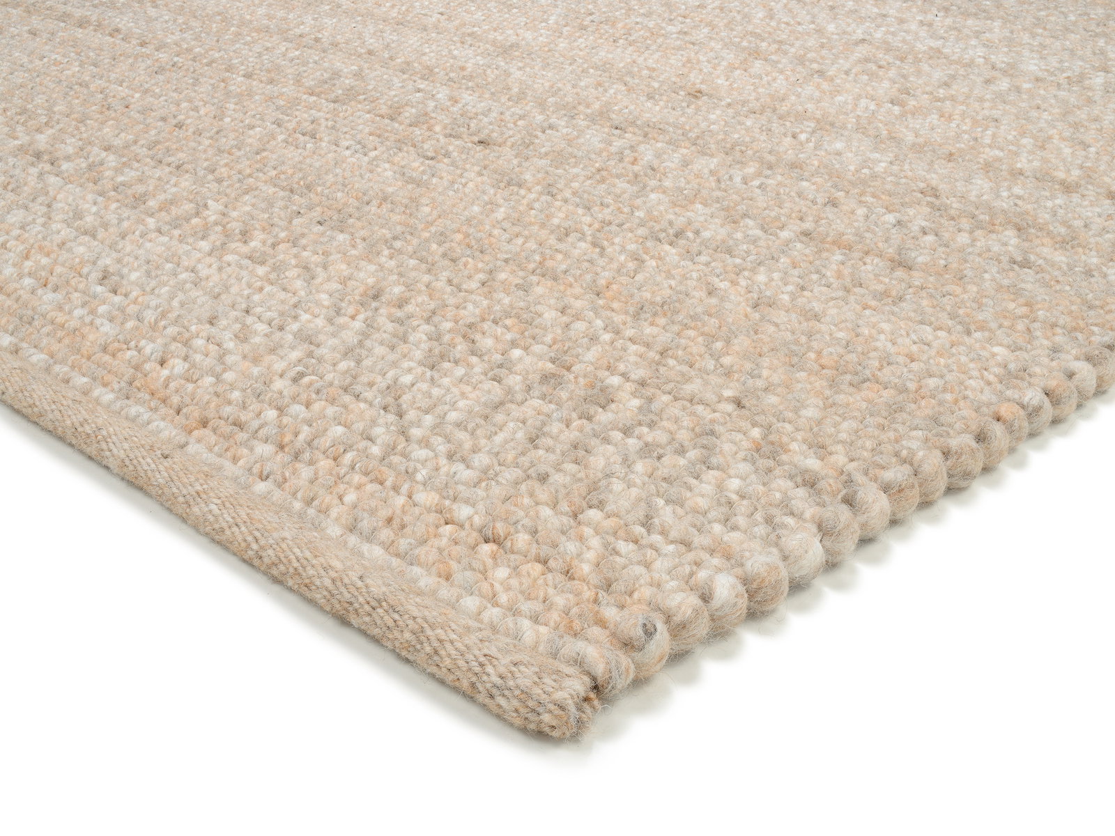 Nahaufnahme eines handgewebten Teppichs in neutralen Beigetönen, perspektivisch von der Seite aufgenommen.