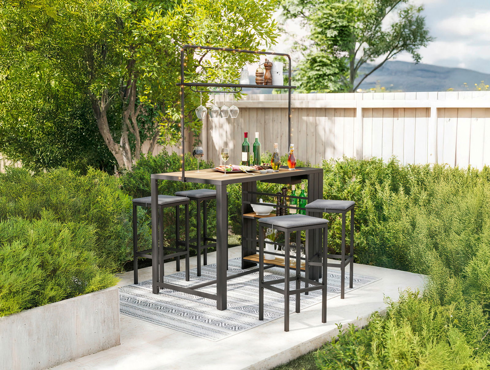 Bar-Set im Garten mit Tisch und Hockern, umgeben von grünen Pflanzen, aus der Perspektive von vorne.