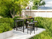 Bar-Set im Garten mit Tisch und Hockern, umgeben von grünen Pflanzen, aus der Perspektive von vorne.