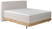 Boxspringbett mit hellem Stoffbezug und Holzunterbau, seitliche Perspektive