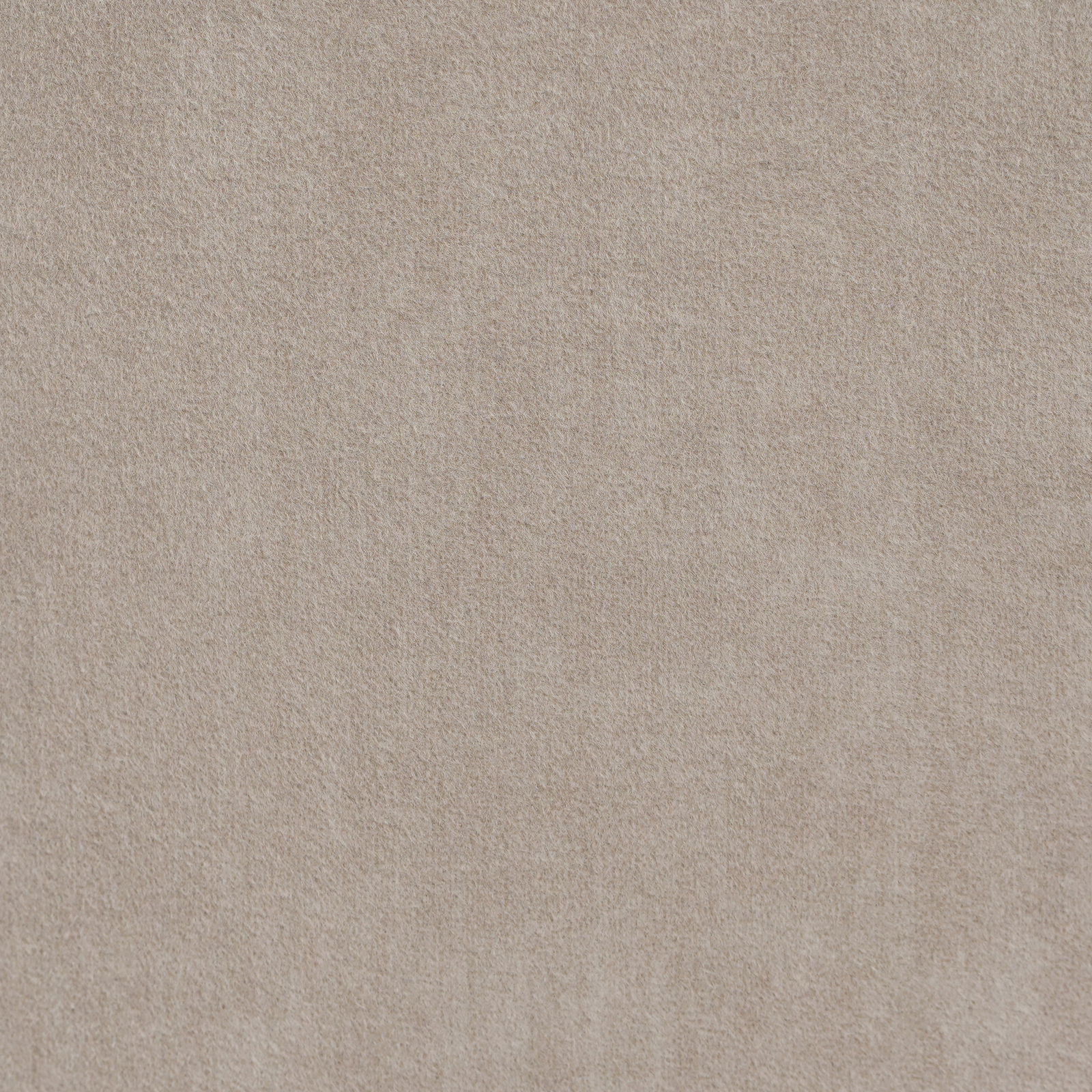 Nahaufnahme eines beigen Stoffes mit weicher Textur, von oben betrachtet.