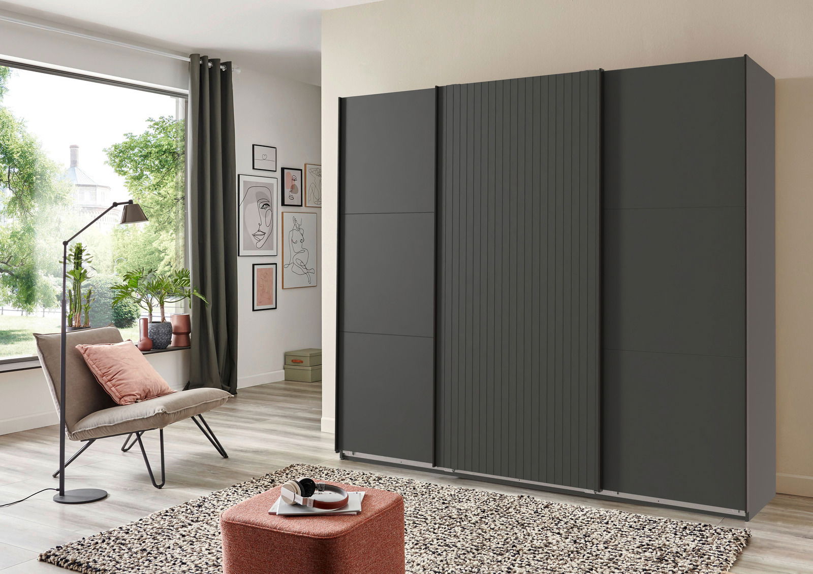 Moderner, dreitüriger Schwebetürenschrank in dunklem Design, seitliche Perspektive im stilvollen Wohnzimmer.